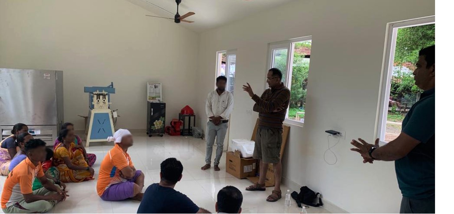 People from Khuded in a training session inside the new Active Building with a speaker from local community organisation Keshav Shrusthi, partners of the Swansea-led SUNRISE team. In the background are the new freezer, flour mill and rice husking machine powered by solar energy